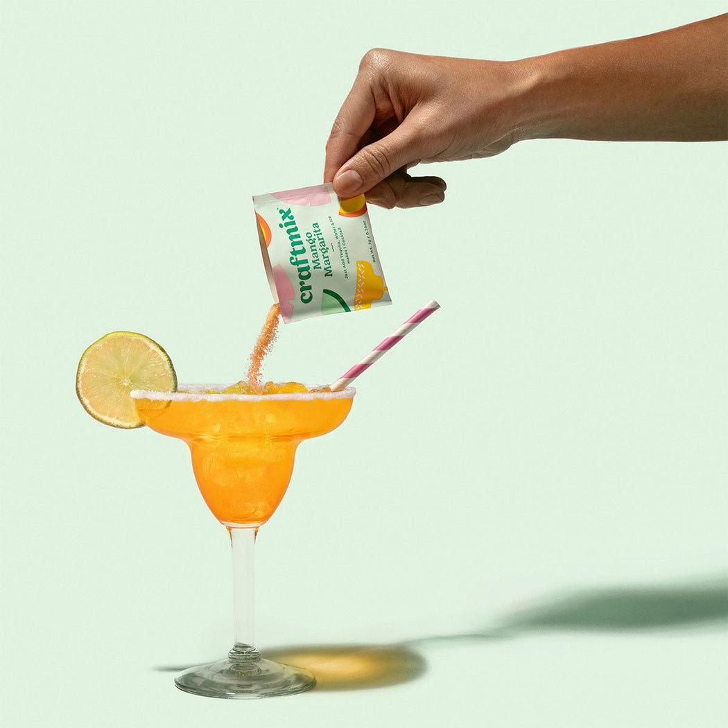Craftmix Cocktail Packet - Mango Margarita - hand pouring packet into a orange margarita glass- Lockwood Shop - Craftmix