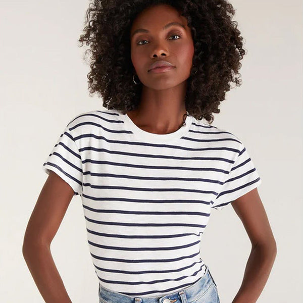 model wearing a white and navy blue striped t styled with demin jeans