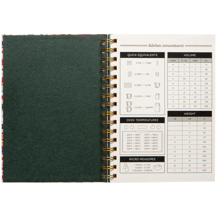 Open spiral-bound notebook with green cover and measurement conversion chart on white pages.