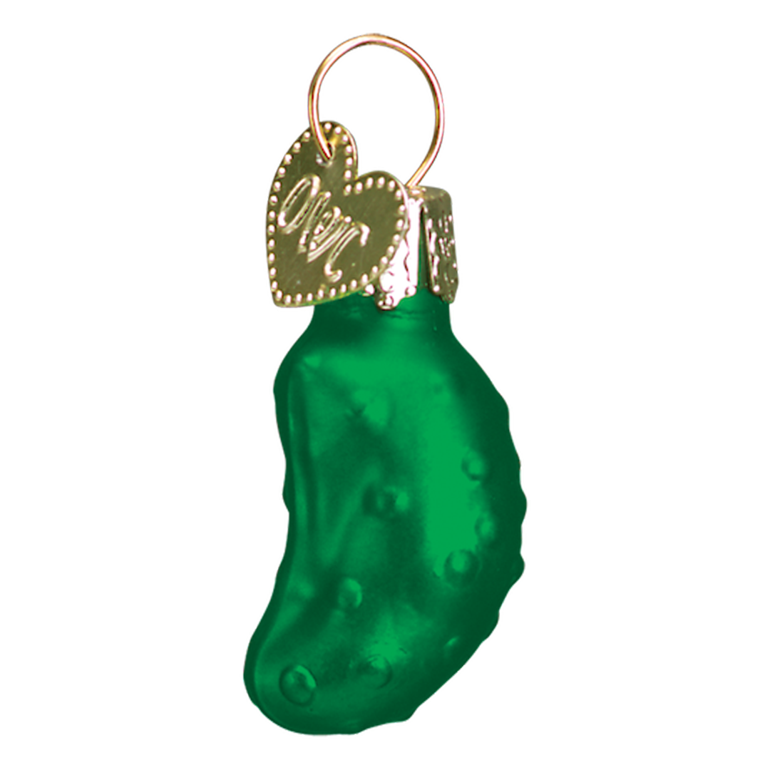 Green pickle-shaped ornament with a gold tag on a white background