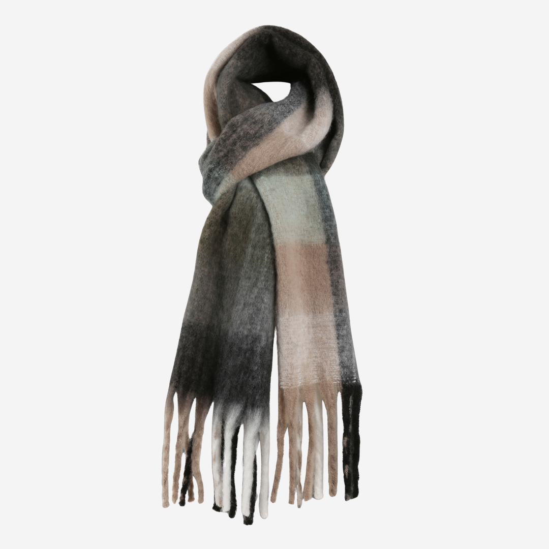 A soft, fuzzy scarf with a plaid pattern in shades of gray, beige, and light green, finished with fringed ends, shown on a plain light gray background.