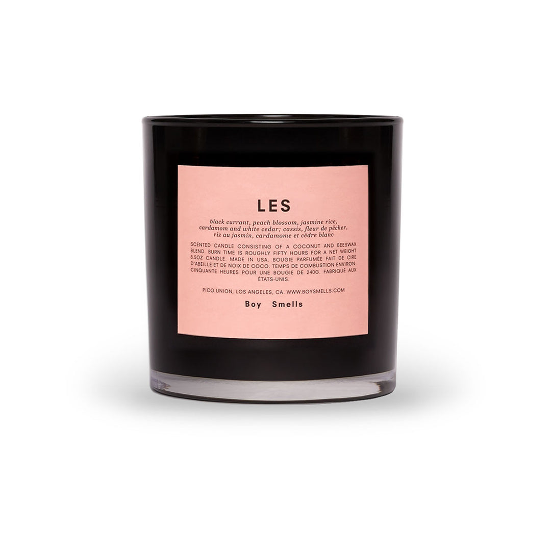 Black candle jar with a pink label that reads &