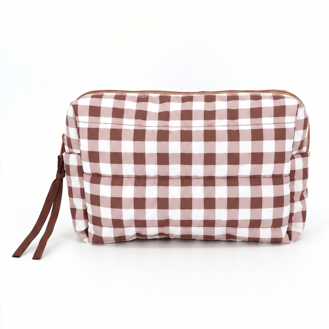 A rectangular zippered cosmetic pouch with a brown and white gingham check pattern, featuring a brown zipper and matching brown strap, shown on a plain white background.