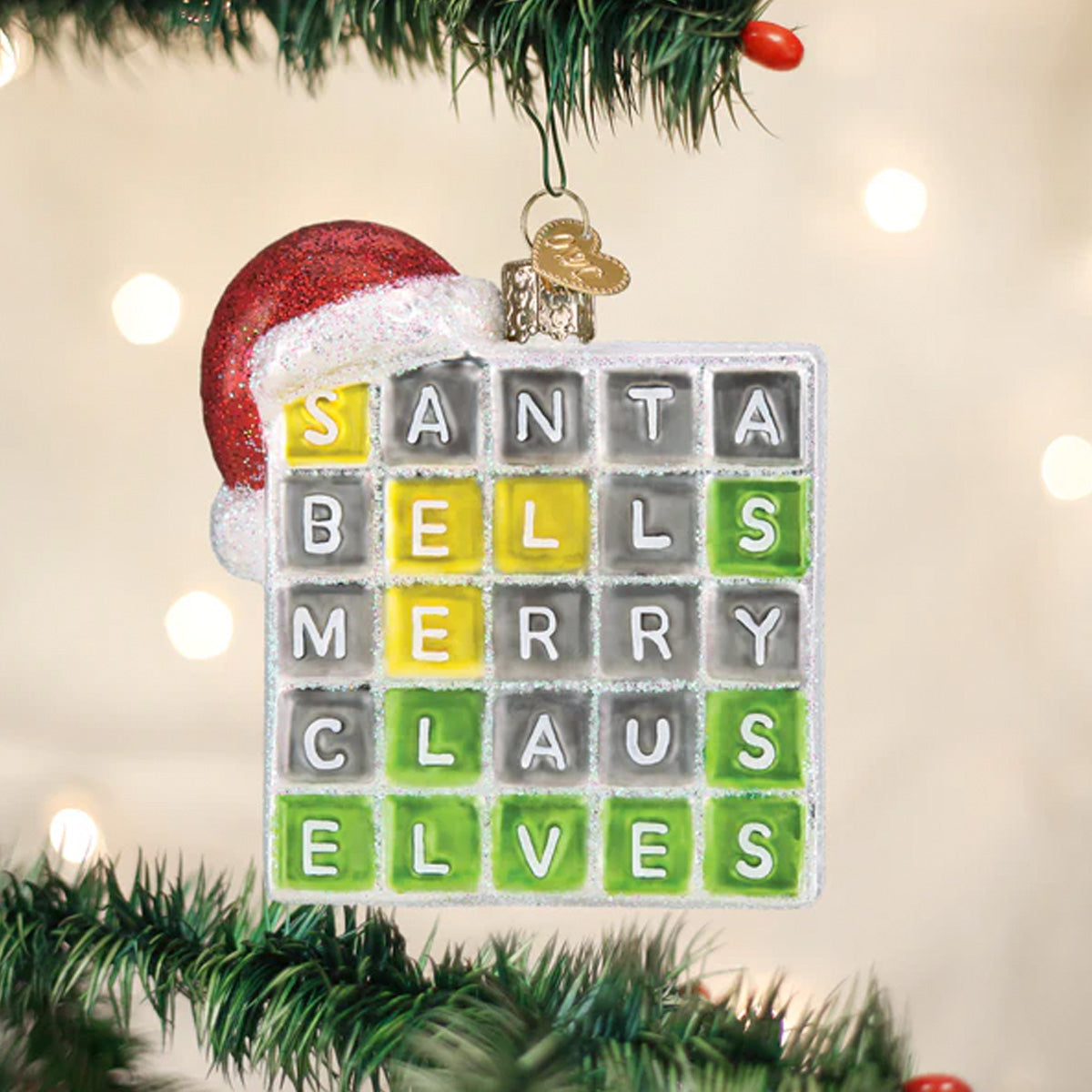 Christmas ornament with a crossword-style design featuring Christmas-themed words, hanging on a tree.