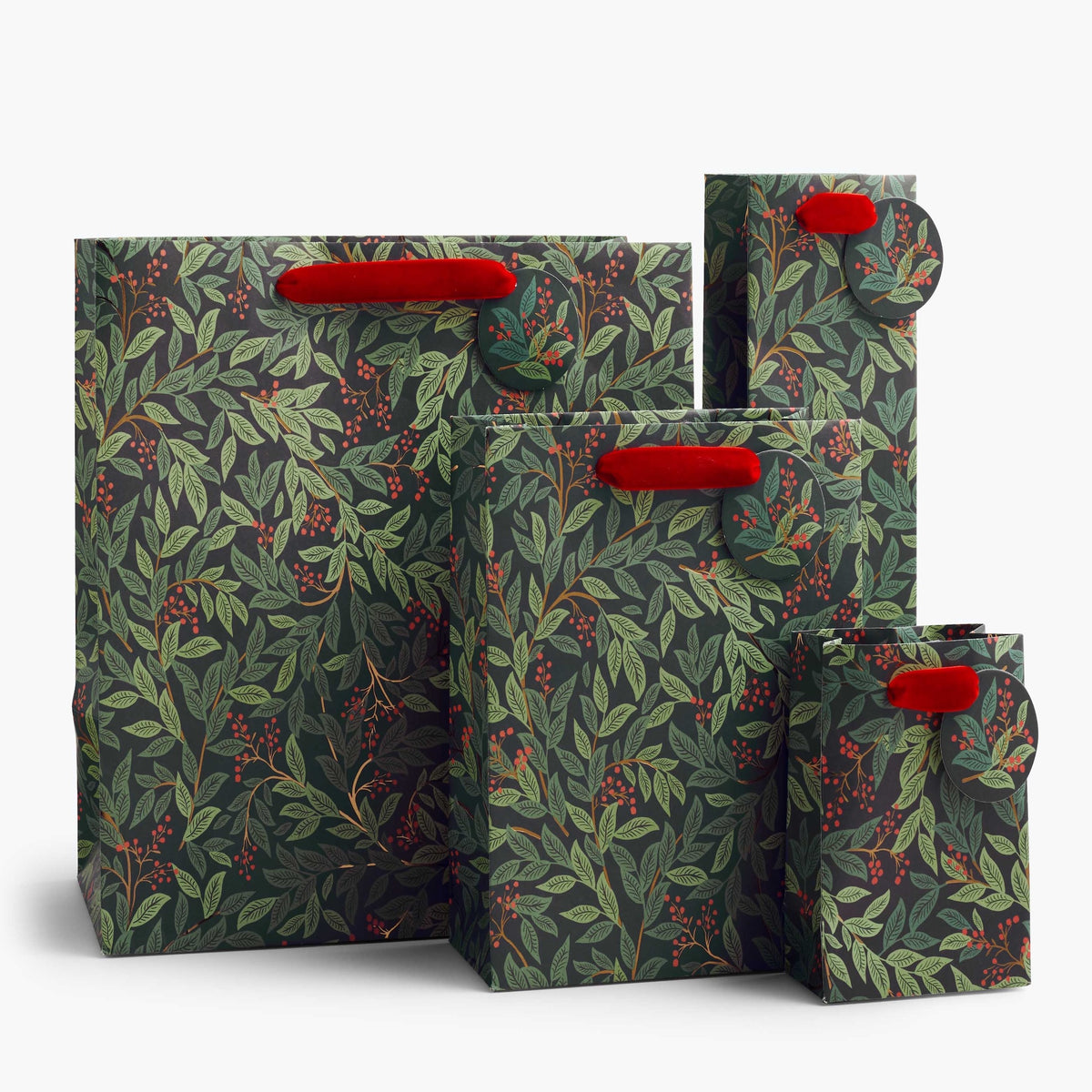 Four nested paper shopping bags with a dark green and gray botanical leaf pattern and bright red handles, shown on a clean white background.