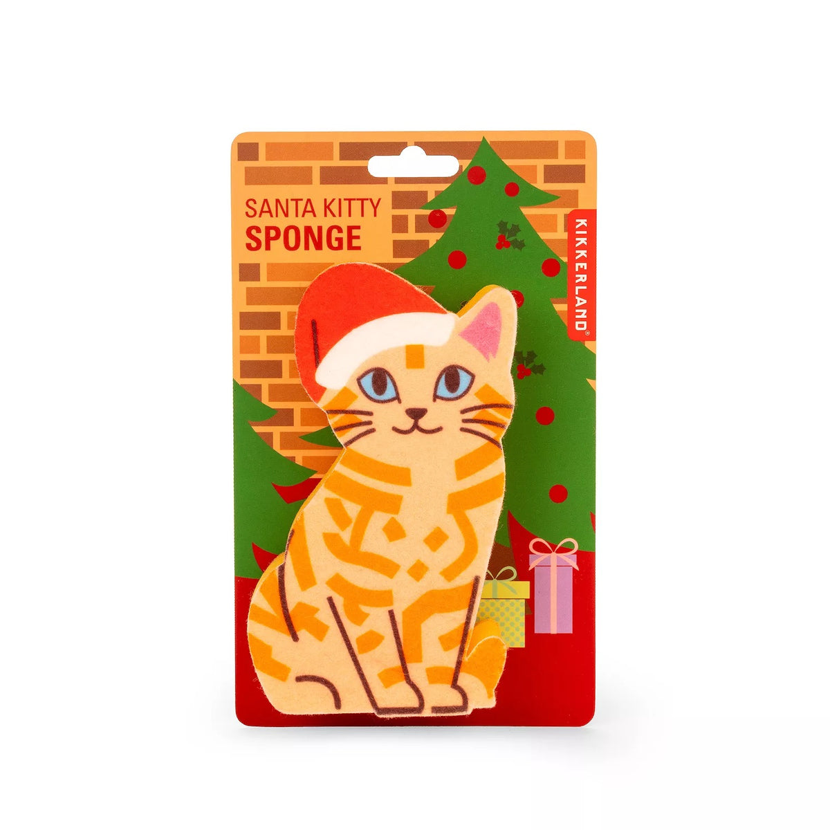 A Christmas-themed cat sponge on its original retail backing card. The product features a stylized orange tabby cat wearing a red Santa hat, set against a festive background with a green Christmas tree, brick wall, and red base.