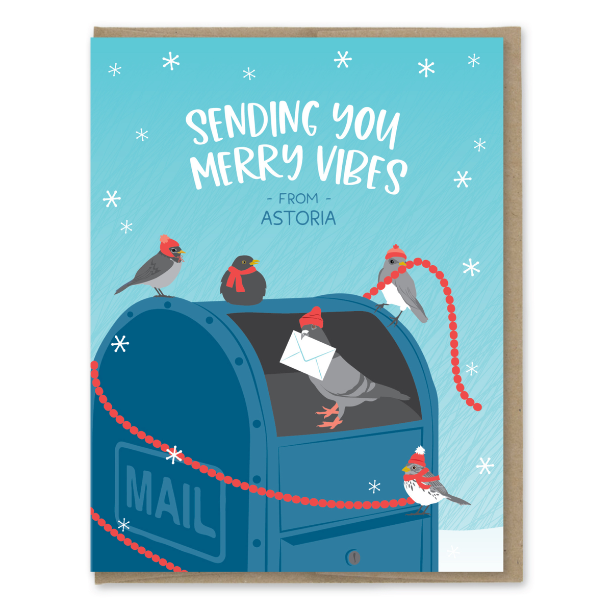 A square greeting card with a kraft envelope behind it, featuring a winter illustration of birds around a blue mailbox and the text 'SENDING YOU MERRY VIBES - FROM - ASTORIA'.