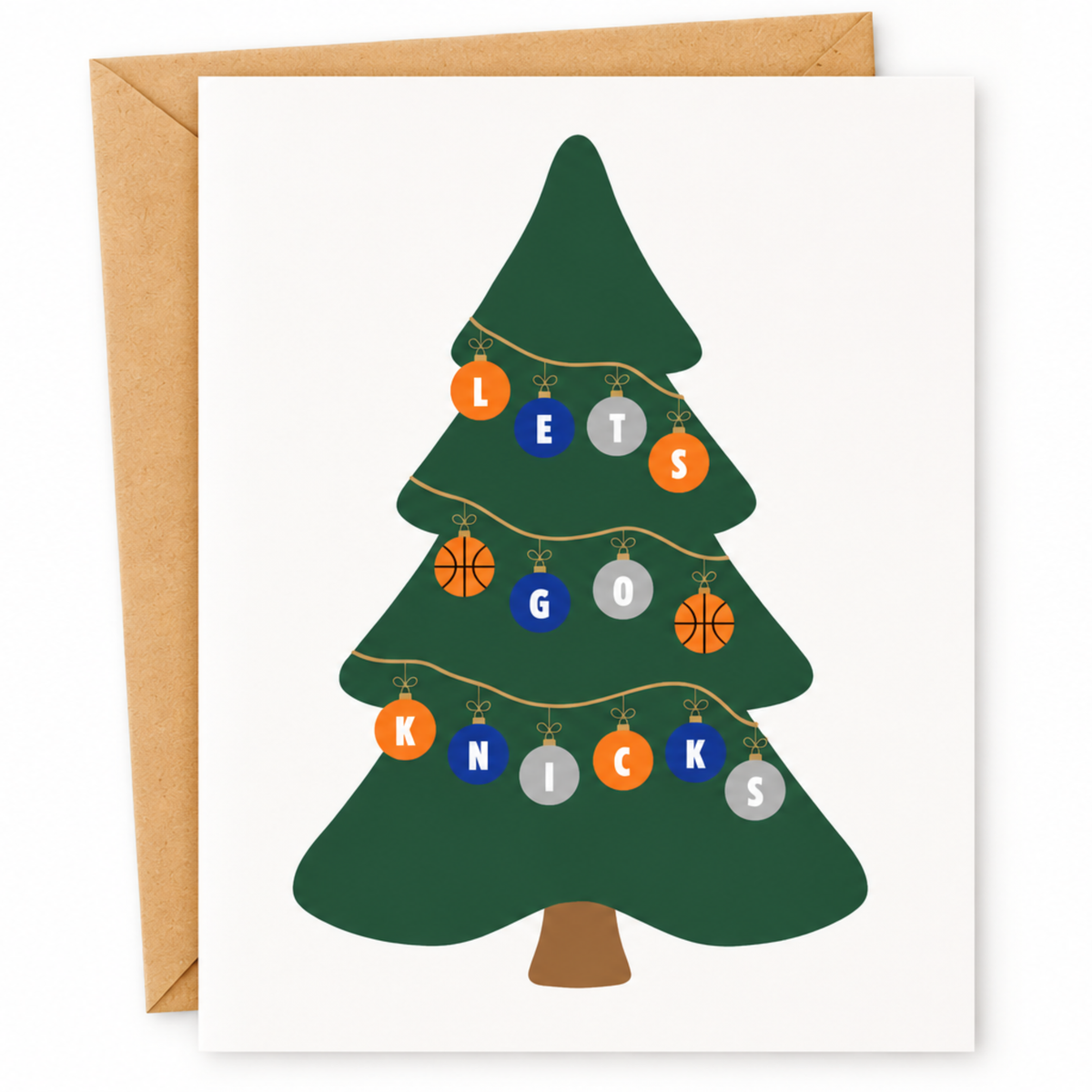 A personalized Christmas greeting card featuring a dark green Christmas tree with basketball-themed ornaments spelling out 'LET'S KNICKS', shown with a brown kraft envelope on a white background.