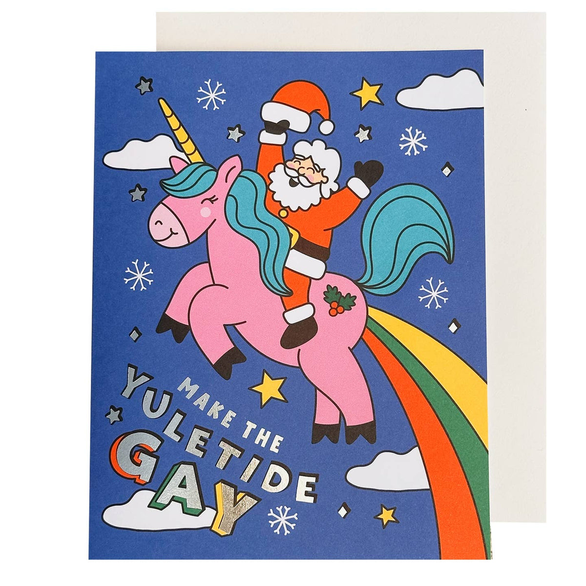 A greeting card featuring a whimsical illustration of Santa Claus riding a pink unicorn with a rainbow tail against a dark blue night sky, with the text 'MAKE THE YULETIDE GAY'. A plain off-white envelope is partially visible behind the card.