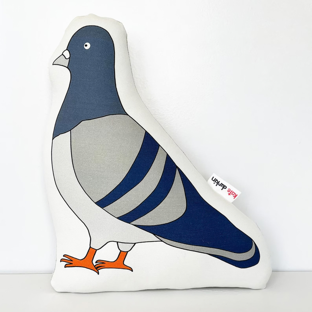 Large bird-shaped throw pillows featuring a stylized pigeon design with a navy blue head, gray body, white wings, and orange feet, set against a plain white background.