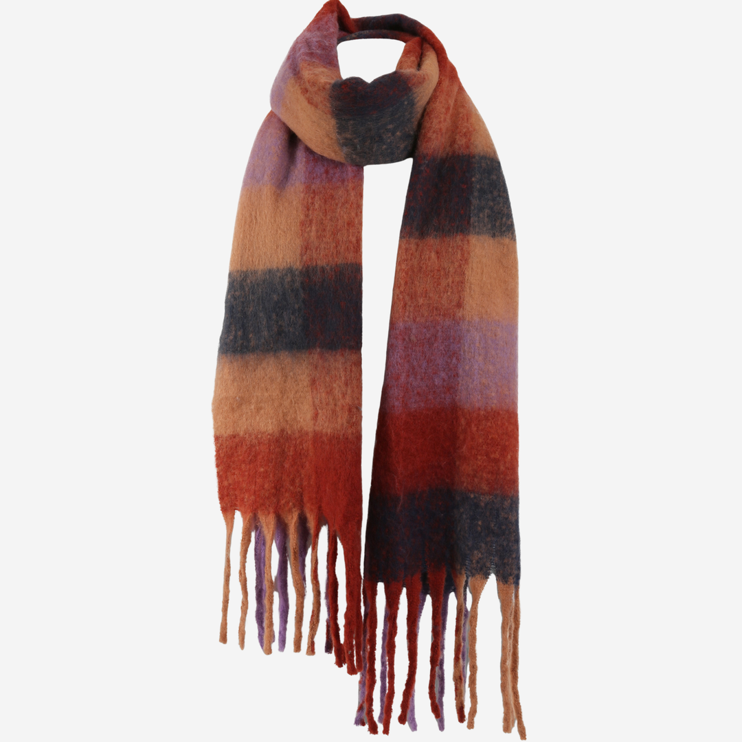 A soft, fuzzy striped scarf with fringe ends, featuring horizontal bands of rust red, orange, brown, purple, and black on a light gray background.