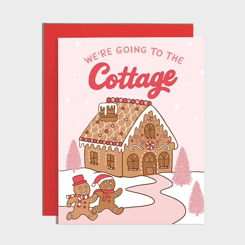 A Christmas greeting card with a red envelope, featuring an illustration of a gingerbread cottage, snow, and two gingerbread people under the text &