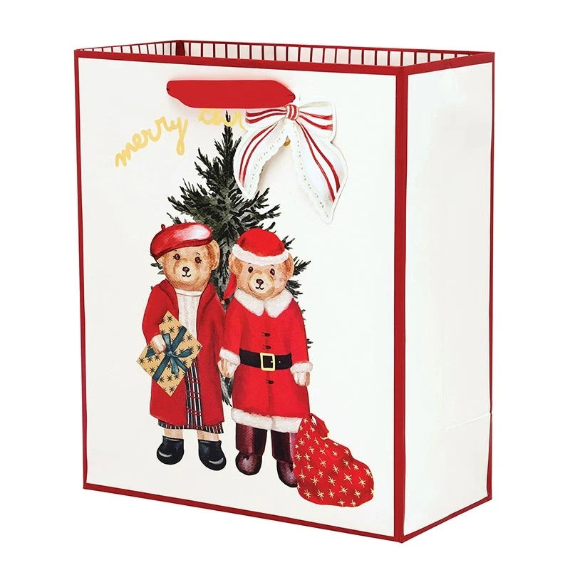 A white Christmas-themed gift bag with red trim, featuring an illustration of two teddy bears dressed as Santa Claus and a red-and-white bow on the front.