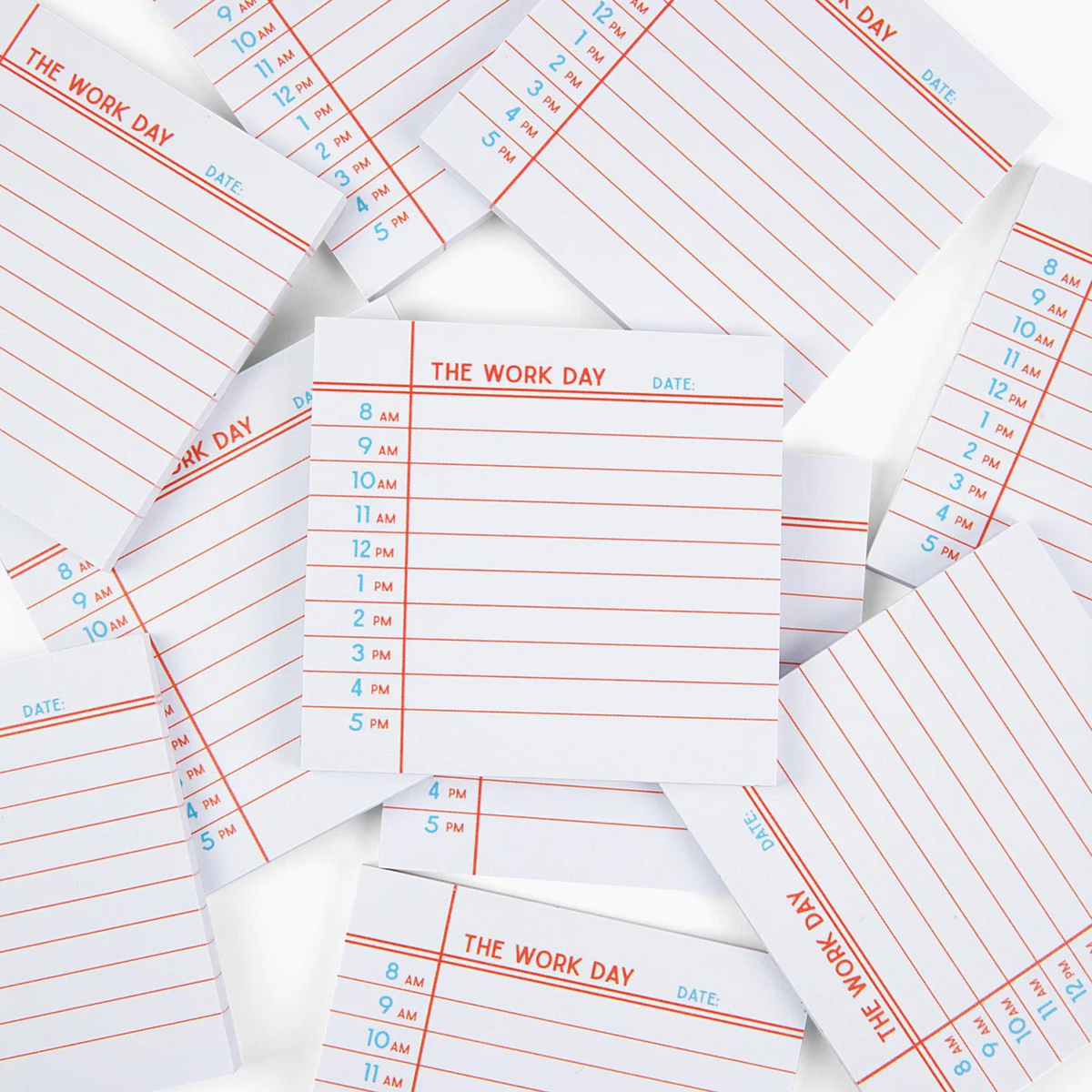 A pile of white notepads with red horizontal lines and blue printed time slots under the heading 'THE WORK DAY,' photographed on a white background.