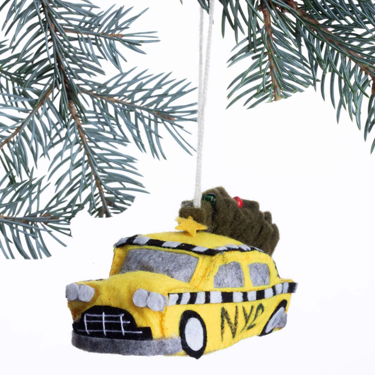 Yellow taxi Christmas ornament with a Grinch on top, hanging from a tree branch.