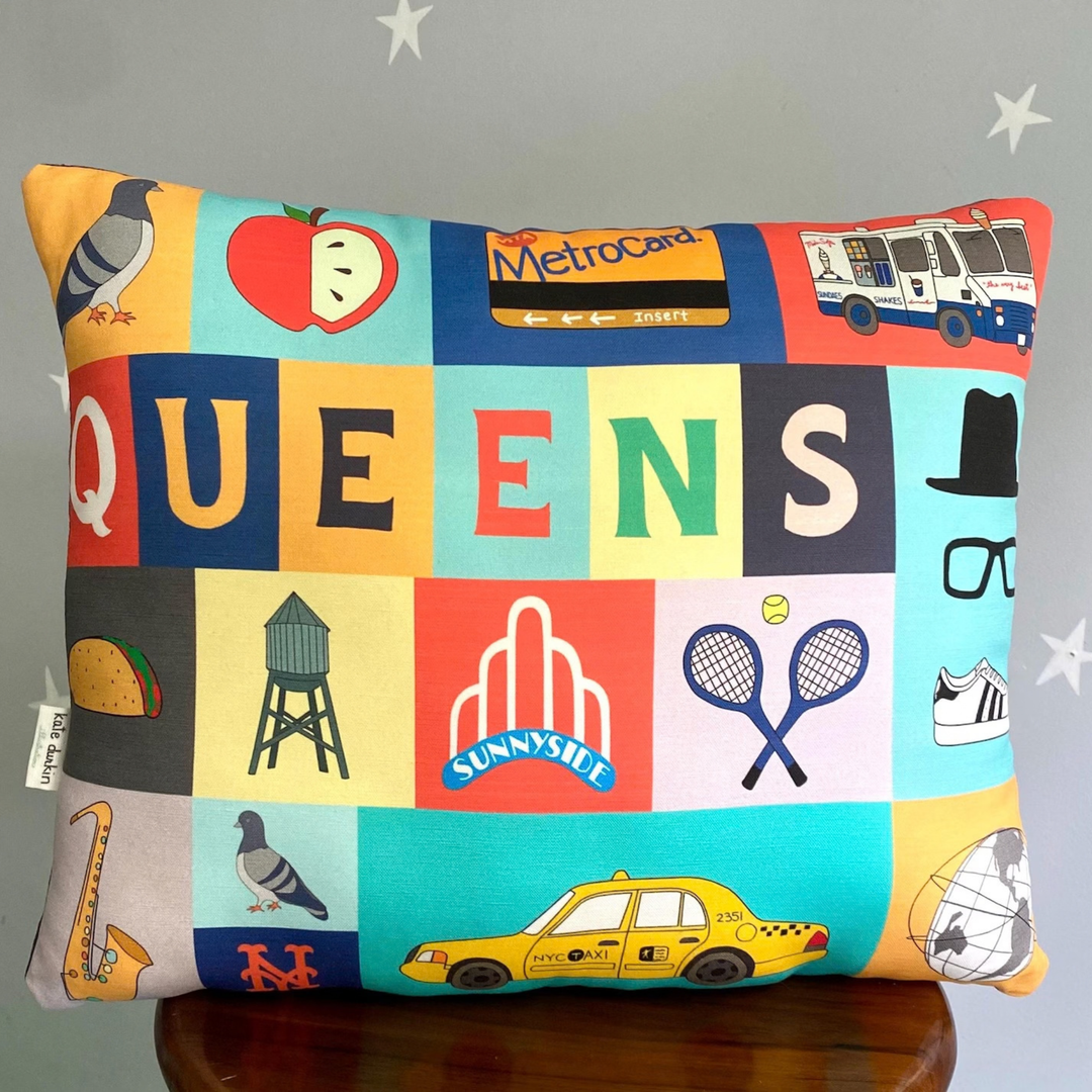 A square decorative throw pillow featuring a colorful patchwork design with the word &
