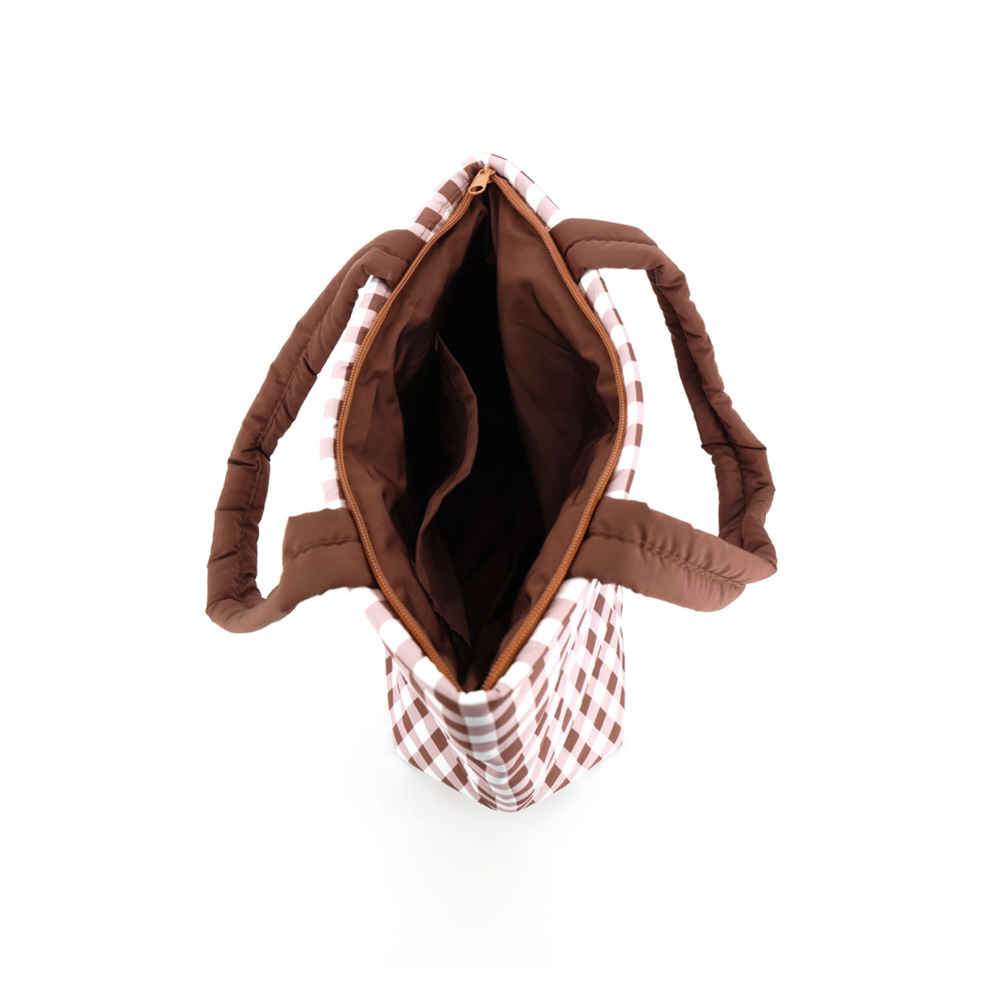 An overhead view of a quilted tote bag with a brown and white gingham pattern exterior, brown padded handles, and a brown interior lining, shown on a white background.